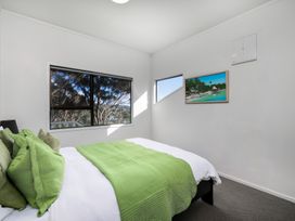 A bedroom with a bed and window at Paua Shell - Coopers Beach Holiday Home