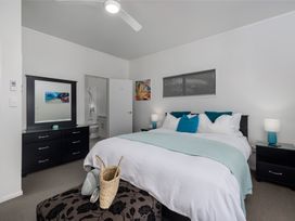 A bedroom with a bed and furniture at Paua Shell - Coopers Beach Holiday Home