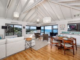 A living room with dining and kitchen area at Paua Shell - Coopers Beach Holiday Home Coopers Beach