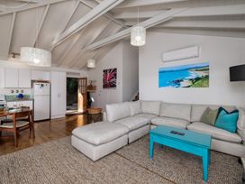 A living room with a sectional sofa and coffee table at Paua Shell - Coopers Beach Holiday Home in Coopers Beach