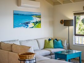 A living room with a sofa and painted artwork at Paua Shell - Coopers Beach Holiday Home