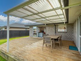 An outdoor patio with a table and chairs at Coromandel Holiday Home in Coromandel