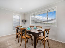 A dining room with a table set for dinner at Coromandel Holiday Home in Coromandel