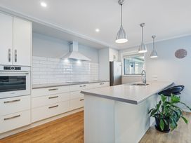 A kitchen with cabinets, sink, and appliances at Coromandel Holiday Home in Coromandel