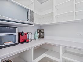 A kitchen counter with a microwave, instant pot, coffee maker and a decorative sign at Coromandel Holiday Home in Coromandel