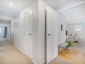 A hallway with doors and a bench at Coromandel Holiday Home in Coromandel