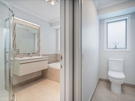 A bathroom with a shower, sink, and toilet at Coromandel Holiday Home in Coromandel