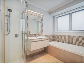 A bathroom featuring a shower, bathtub, and a vanity at Coromandel Holiday Home in Coromandel