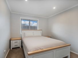 A bedroom with a bed and nightstand at Coromandel Holiday Home in Coromandel