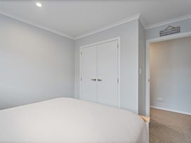 A bedroom with a bed and wardrobe at Coromandel Holiday Home in Coromandel