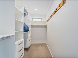 A closet with shelves and hanging space at Coromandel Holiday Home in Coromandel