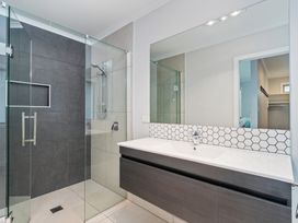 A bathroom with a shower and sink at Coromandel Holiday Home in Coromandel
