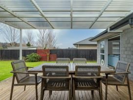 A patio with a table and chairs at Coromandel Holiday Home in Coromandel