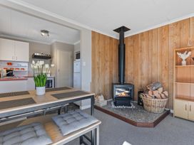 A living room with a stove and dining table at All Year Round Adventure Base - National Park