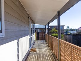 A balcony with wooden railing and glass door at All Year Round Adventure Base - National Park