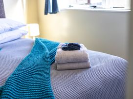 A bed with towels folded beside a lamp at All Year Round Adventure Base - National Park