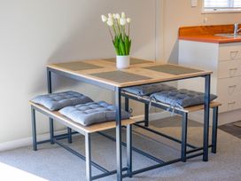 A dining table with cushions and a flower pot at All Year Round Adventure Base - National Park