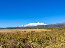A scenic view of a snow-capped mountain with fields at All Year Round Adventure Base - National Park