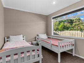 A bedroom with two beds and a window at Mangawhai Heads Holiday Home in Mangawhai