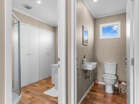 A bathroom with a toilet and sink at Mangawhai Heads Holiday Home in Mangawhai