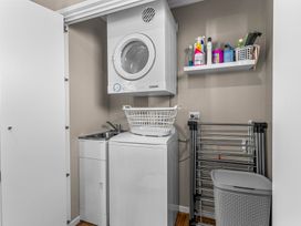 A laundry room with a washing machine and dryer at Mangawhai Heads Holiday Home Mangawhai