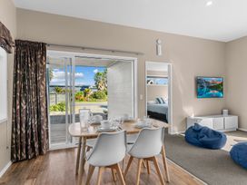 A dining room with a table and chairs at Mangawhai Heads Holiday Home in Mangawhai
