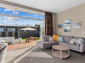 A living room with a sofa and coffee table at Mangawhai Heads Holiday Home in Mangawhai