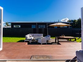 An outdoor space with seating and a table at Mangawhai Heads Holiday Home in Mangawhai