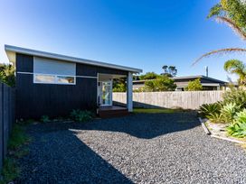 A house with a gravel driveway at Mangawhai Heads Holiday Home in Mangawhai