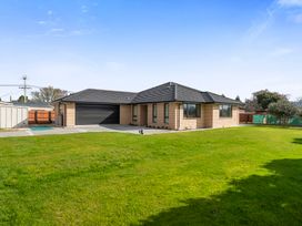 A house with a garage and lawn at Repatoa Holiday Home in Repatoa