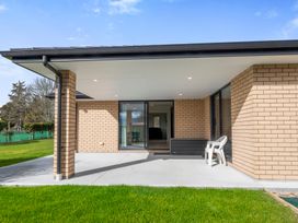 An outdoor patio area with a chair and a lawn at Repora Holiday Home in Repora