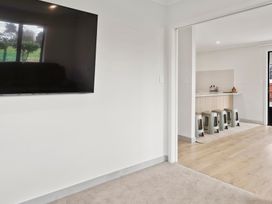 A living room with a television and doorway to kitchen at Reporoa Holiday Home in Reporoa