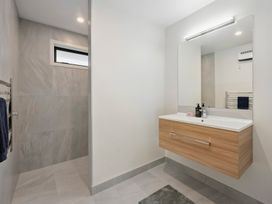A bathroom with a shower and a vanity at Repora Holiday Home, Reporoa