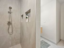 A shower with a stainless steel shower head in a bathroom at Reporoa Holiday Home in Reporoa