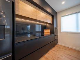 A kitchen with dark cabinets and a countertop at Te anau Holiday home in Te Anau