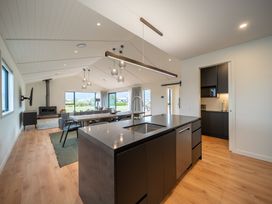 A kitchen island with a sink and a dining area at Te anau Holiday home in Te Anau