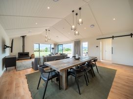 A living room with a dining table and sofa at Te anau Holiday home in Te Anau