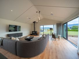 A living room with a sofa and television at Te anau Holiday home in Te Anau