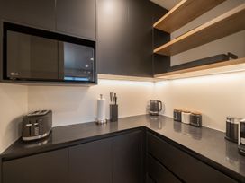 A kitchen with appliances and storage at Te anau Holiday home in Te Anau