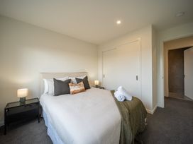 A bedroom with a bed and bedside table at Te anau Holiday home in Te Anau
