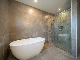 A bathroom with a bathtub and a shower at Te anau Holiday home in Te Anau
