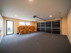 A garage with wood storage and a door at Te anau Holiday home in Te Anau