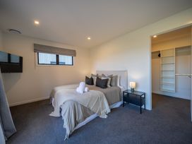 A bedroom with a bed and a lamp at Southern Solace - Te Anau Holiday Home Te Anau