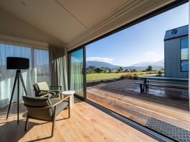 A living room with a view of a deck and mountains at Southern Solace - Te Anau Holiday Home in Te Anau