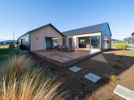 A house with a wooden deck and outdoor furniture at Southern Solace - Te Anau Holiday Home, Te Anau