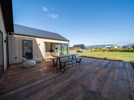 An outdoor deck area with a table and bean bags at Southern Solace - Te Anau Holiday Home in Te Anau