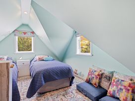 A bedroom with two beds and a nightstand at Akaroa Holiday Home