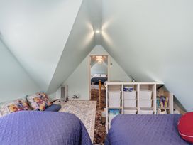 A bedroom with two beds and a shelf at Akaroa Holiday Home