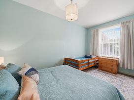 A bedroom with a large bed and a bunk bed at Akaroa Holiday Home