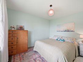 A bedroom with a bed and a chest of drawers at Akaroa Holiday Home